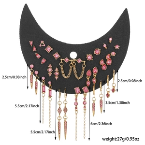Parure de boucles d'oreilles gothiques dorées avec pierres roses sur présentoir