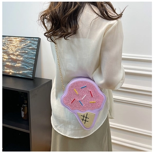 Pink glitter ice cream crossbody bag with sprinkles and a gold chain strap on model