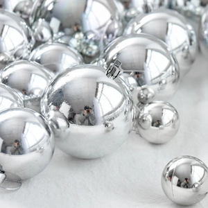 Polished silver Christmas ornaments set in various sizes on white soft fur background