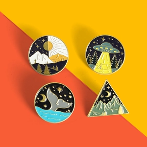 Detailed view of four nature and sci-fi enamel pins featuring whale tails and UFO designs