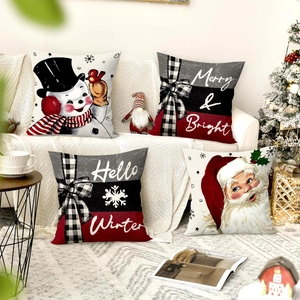 Set of 4 Christmas throw pillow covers with snowman and Santa designs on a sofa