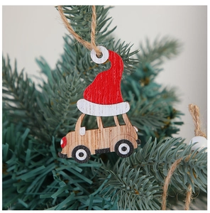 Detail of wooden Christmas car ornament with red hat hanging on a pine tree branch