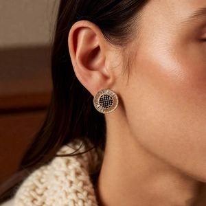 Detail of vintage round earrings with black and white crystals on a gold plated base