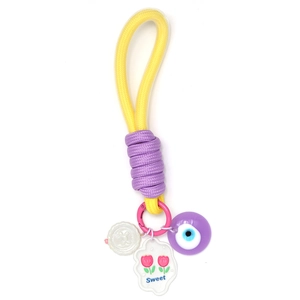 Détail d'un porte-clés tressé jaune avec perle œil maléfique violette et breloque Sweet