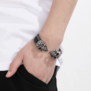 Detailed view of skull head ends on a black braided wire bracelet for men