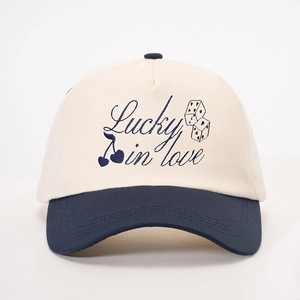 Detail of Lucky in Love embroidery on a two-tone cotton baseball cap with heart and dice