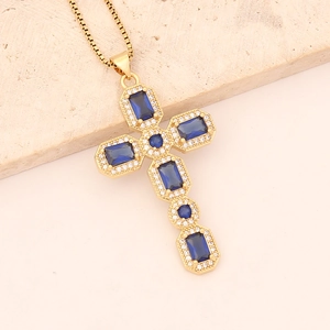 Detailed view of a gold cross necklace with blue rectangular stones and clear cubic zirconia