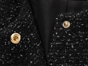 Détails de la texture en tweed noir et des boutons dorés d'un ensemble élégant