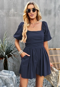 Detail view of dark blue square neck romper with pleated waist and functional pockets