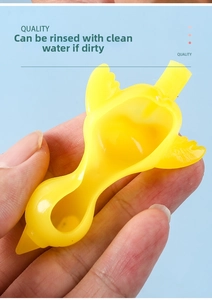 Detail of yellow TPR flick chicken toy being pinched to show soft, washable material texture