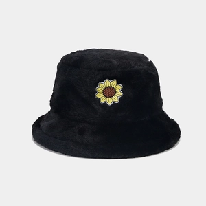 Dettaglio del ricamo a girasole sul cappello alla pescatore in peluche nero con finta pelliccia
