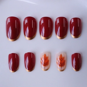 Faux ongles bordeaux avec motifs feuilles d'érable et bordure dorée style French