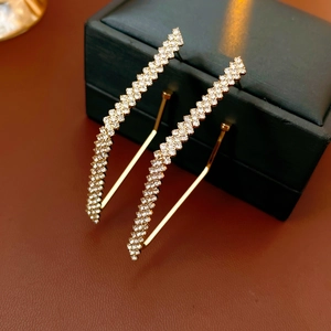 Dettaglio di orecchini a cerchio geometrici a zigzag dorati con cristalli scintillanti