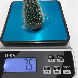 Mini-Tannenbaum mit Kunstschnee auf einer Digitalwaage mit einem Gewicht von etwa 7,5g