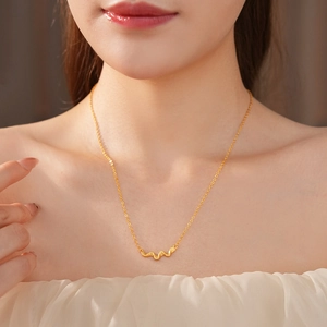 Close-up of a vintage gold wavy pendant necklace on neck with elegant brushed finish