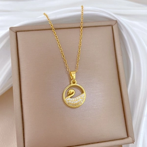 Elegant gold hollow swan necklace with sparkling crystals in a jewelry box