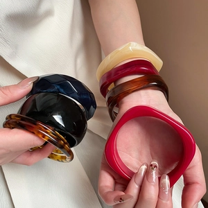 Close-up of colorful acrylic resin bangles with leopard print and wavy textured designs