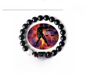 Détail macro du bracelet Balance en agate noire avec breloque zodiaque et fond étoilé