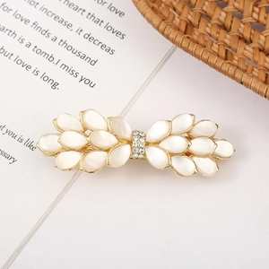 Macro shot of an elegant bow hair clip featuring cat's eye stones and sparkling crystals