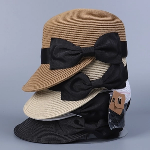 Dettaglio dei cappelli da sole in paglia intrecciata con fiocchi neri in vari colori