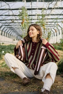 Close-up of retro striped knit sweater with half-button collar and colorful patterns