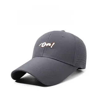 Close-up of dark grey breathable baseball cap with white 'on!' embroidery and side vents