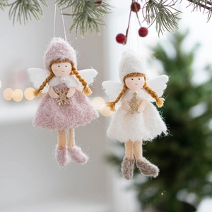 Close-up of pink and white felt angel ornaments with wings on a Christmas tree branch