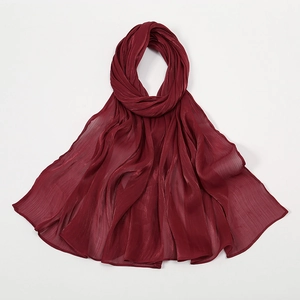 Detailansicht eines weinroten Chiffonschals mit eleganter Faltenstruktur und Glanzeffekt
