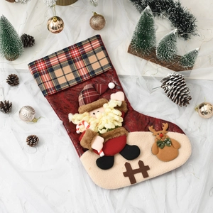 Close-up of festive Christmas stocking with Santa and reindeer plush figures on red fabric