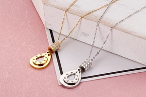 Detail of gold and silver teardrop pendants with sparkling crystals on thin chain necklaces