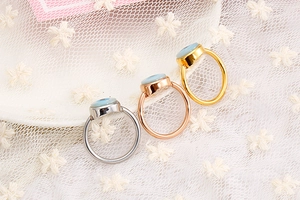 Detailed view of evil eye rings in gold, silver, and rose gold on white lace background