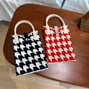 Détails de la texture tricotée du sac panda avec poignées rondes et motifs à vagues