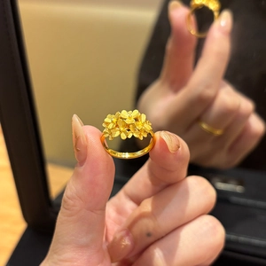 Detail of elegant gold-plated floral open ring with matte textured petals and glossy band