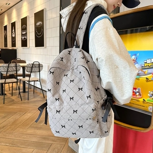 Cute cream backpack with quilted diamond pattern and black bow prints for students