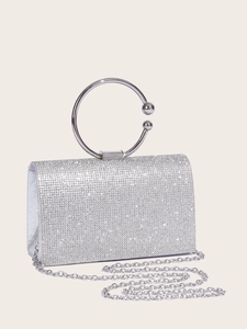 Detailed macro of silver rhinestone clutch featuring round metal handle and chain strap
