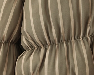 Close-up of military green and beige striped fabric with ruched pleated details