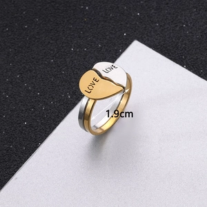 Detailed view of titanium steel love rings with interlocking heart and LOVE engraving