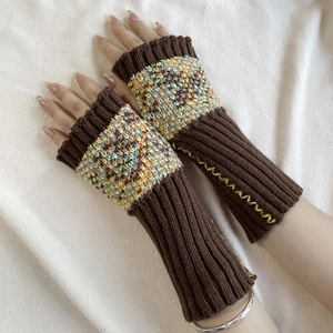 Close-up of knit fingerless gloves with colorful pattern on cuffs in dark brown