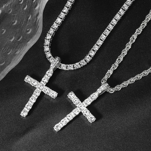Iced out silver cross pendants on tennis chain and rope chain over dark fabric