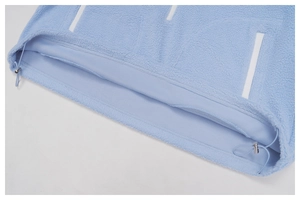 Detail of light blue fleece jacket hem featuring adjustable elastic drawstring and metal toggles