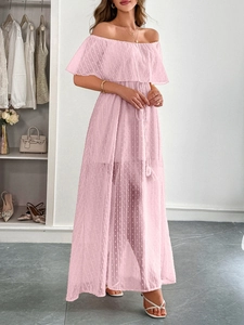 Dettaglio dell'abito in chiffon rosa a pois con scollatura a barchetta e nappine eleganti