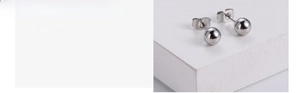 Detail of polished silver round bead earrings with butterfly backs on white surface