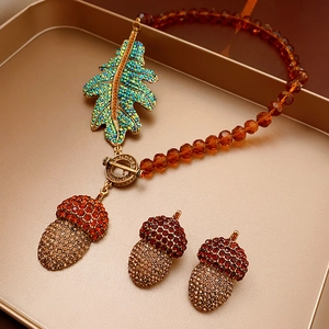 Detailed set of vintage necklace and earrings with amber beads and crystal acorn pendants