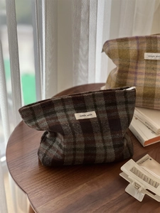 Detailed view of vintage plaid fabric cosmetic bags with simple wish labels on a table