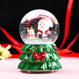 Dreamy Christmas snow globe music box with Santa and reindeer on a decorative base