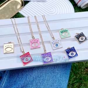 Makroansicht verschiedener quadratischer Evil-Eye-Anhänger mit Kristalldekor und Goldkette