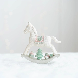 Détail d'un cheval à bascule de Noël en résine avec texture tricotée et mini boîte cadeau