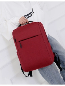 Red minimalist laptop backpack with USB port and large capacity shown by male model