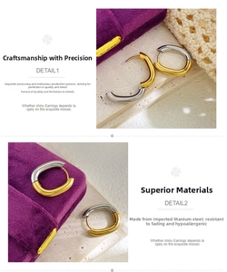 Macro detail of two-tone gold and silver titanium steel U-shaped earrings on jewelry box