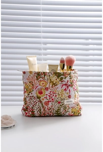 Close-up of vintage floral jacquard makeup bag with woven fabric texture and logo label